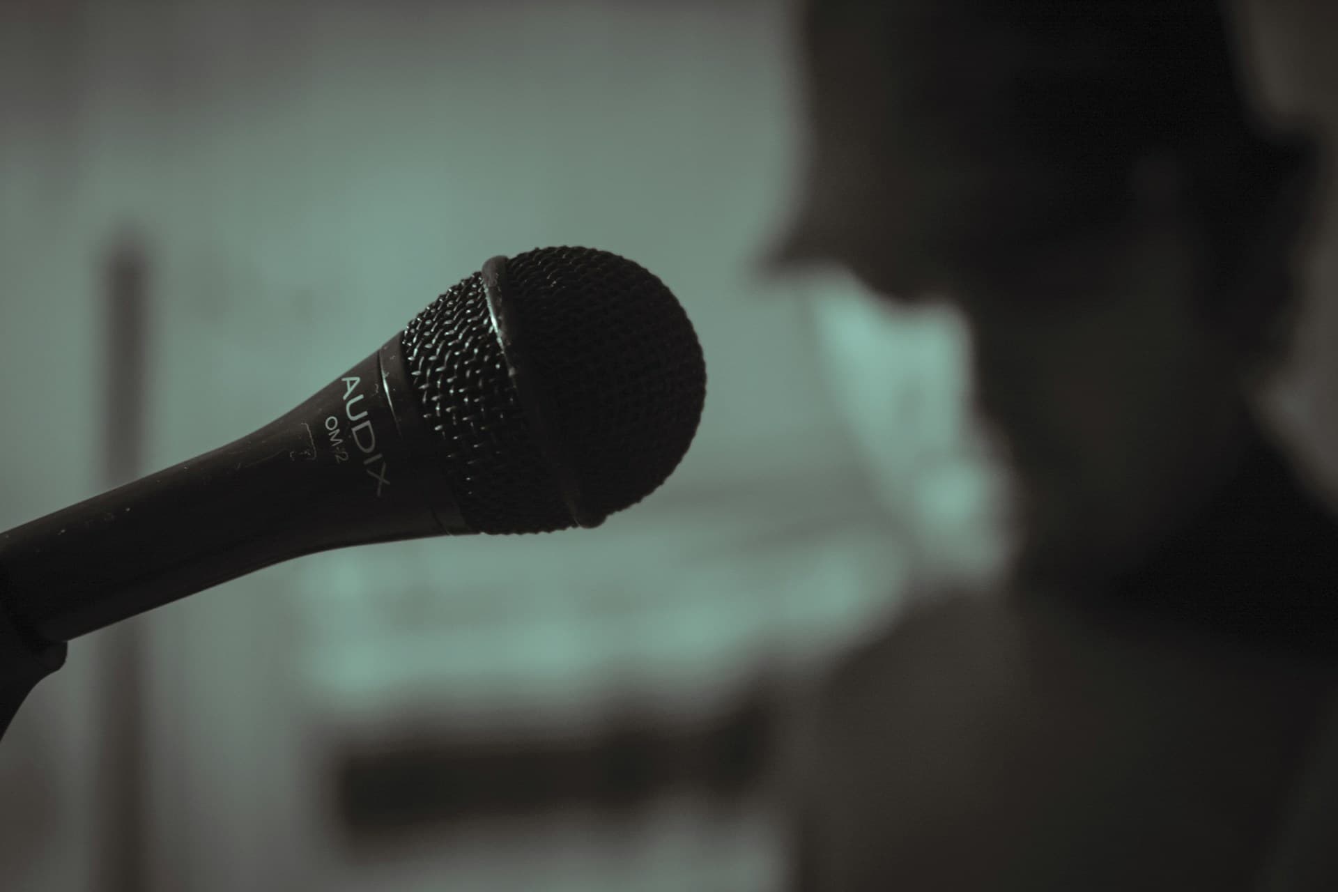 Person practicing clear speaking with a microphone and notes